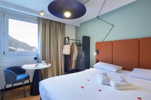 Una habitación de hotel con una cama, una mesa y una ventana. en Ibis Sallanches Porte du MontBlanc, en Sallanches 28 fotos más