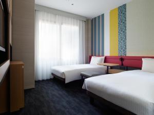 a hotel room with two beds and a window at Mitsui Garden Hotel Kyoto Shijo in Kyoto