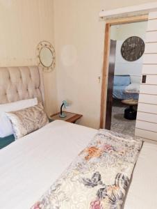 GqeberhaにあるRichmond Hill Guesthouse & Luxury Suitesのベッドルーム1室(白い掛け布団付きのベッド1台付)