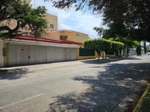 an empty street next to a building with a tree at Habitación 3 CHAPALA in Guadalajara