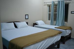Un pat sau paturi într-o cameră la Swagath guest inn hampi