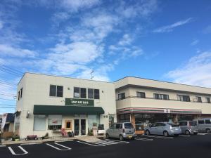 a building with cars parked in a parking lot at Apartment in Narita 102 in Narita