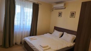 ein Schlafzimmer mit einem Bett, auf dem zwei Handtücher liegen in der Unterkunft Tineretului in Bukarest