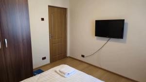 Zimmer mit einem Bett und einem TV an der Wand in der Unterkunft Tineretului in Bukarest