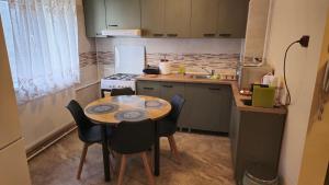 eine kleine Küche mit einem Holztisch und Stühlen in der Unterkunft Tineretului in Bukarest