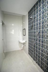un baño con lavabo y ducha en Ena Holiday Inn, en Calangute
