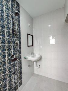 un baño con lavabo y ducha en Ena Holiday Inn, en Calangute 67 fotos más