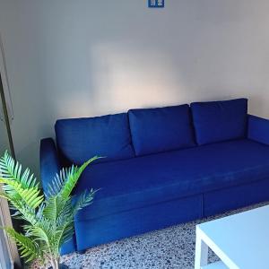 a blue couch in a living room with a plant at María PLAYA ARENA NG in Peniscola