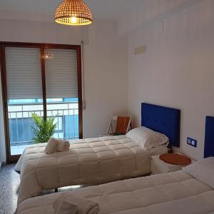 a bedroom with two beds and a large window at María PLAYA ARENA NG in Peniscola
