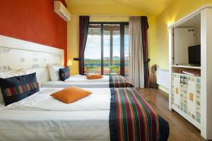 two beds in a hotel room with orange walls at Hotel Casa Art in Oreshak