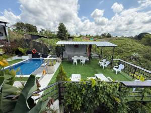 a backyard with a swimming pool and a yard with chairs at Villa del lago in Quimbaya
