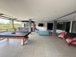 a living room with a ping pong table in the middle at Villa del lago in Quimbaya
