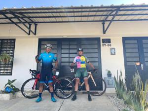 deux hommes debout devant une maison avec leurs vélos dans l'établissement Home Eliz El espacio perfecto, à Cartago