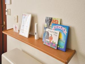 a wooden shelf with books on a wall at mve in Obihiro