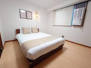 Postel nebo postele na pokoji v ubytování Neighbor's Hotel 十日市