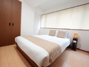 Postel nebo postele na pokoji v ubytování Neighbor's Hotel 十日市