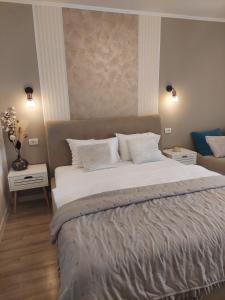 a bedroom with a large bed with white sheets and pillows at ALDIRA Studio Arena Nationala in Bucharest