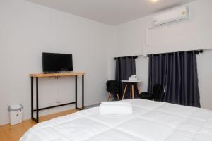a bedroom with a white bed and a flat screen tv at 22 Hostel in Chiang Mai