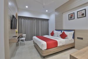 a hotel room with a bed and a desk and a desk at RAMAINn HOTEL in Anand