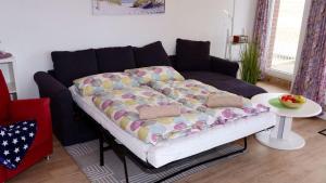 a couch with a blanket on it in a living room at Haus-Nordseeperle-11 in Cuxhaven