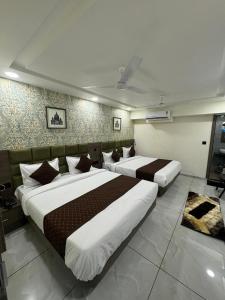 two beds in a hotel room with two bedsvisor at Hotel HR fortune gota in Ahmedabad +21 photos