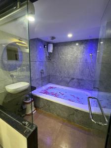 a bathroom with a tub and a sink at Hotel HR fortune gota in Ahmedabad