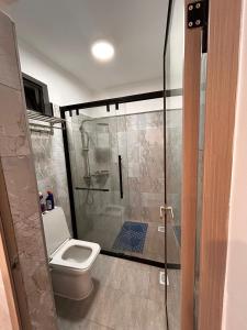 a bathroom with a shower with a toilet and a glass shower door at Calm cozy home in Eldoret Airport