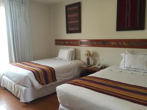 Postel nebo postele na pokoji v ubytování Taypikala Hotel Cusco