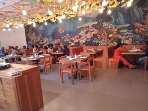 a restaurant with people sitting at tables and a mural at Blackpool Complex - Lavender in Trincomalee