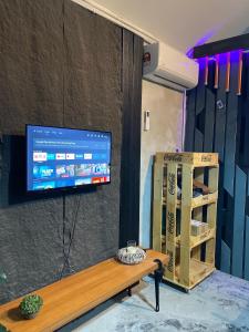 a tv on a wall with a table and a box at Kerlingfornia Pond View Farm House in Kerling +21 photos