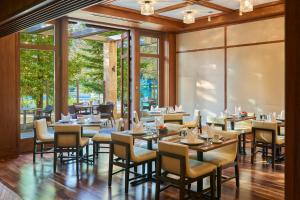 um restaurante com mesas e cadeiras e janelas grandes em The Clement Hotel - All Inclusive Urban Resort em Palo Alto