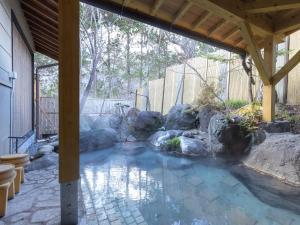 een zwembad met rotsen in een tuin bij Tabist Kazeyuki in Takayama