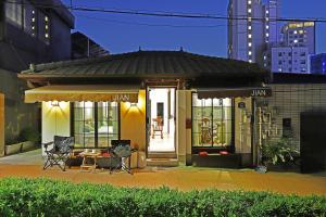 ein Gebäude mit einem Tisch und Stühlen davor in der Unterkunft Jian Hanok in Seoul