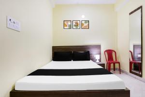 a bedroom with a bed and a red chair at Hotel O Divisha palace in Gaya