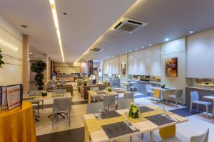 a dining room with tables and chairs and a restaurant at La Breza Hotel in Manila