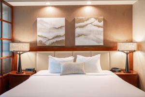 a bedroom with a large white bed with two lamps at No Resort Fee Strip View Suite+ Free Valet + Pool in Las Vegas +28 photos