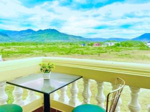 ein Tisch auf einem Balkon mit Bergblick in der Unterkunft Polin Hotel in Phumĭ Kaôh Tasai