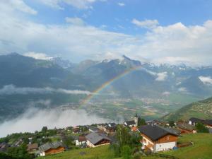 a rainbow over a town with a mountain at Apartment in Veysonnaz near Ski Gondola in Veysonnaz