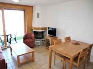 a living room with a wooden table and a television at Cozy Apartment With Valley Views in Veysonnaz +24 photos