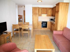 a living room with a couch and a table and a kitchen at Cozy Apartment With Valley Views in Veysonnaz