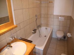 a bathroom with a tub and a sink and a toilet at Cozy Apartment With Valley Views in Veysonnaz