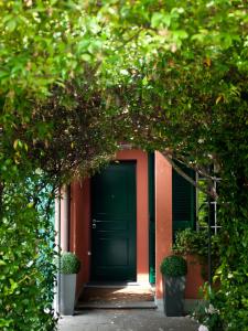 a green door of a house with trees at Elena's Home in Basiglio