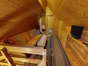 a small room with a couch and a tv in a cabin at Holiday Home Bodensdorf near Gerlitzen Ski Area in Tratten