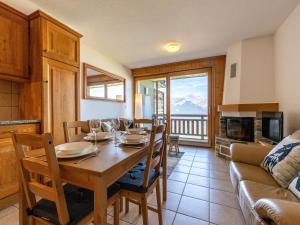 a dining room with a table and a couch at Nice apartment with valley view in Veysonnaz