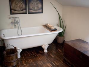 a bath tub in a bathroom with a wooden floor at Elena's Home in Basiglio