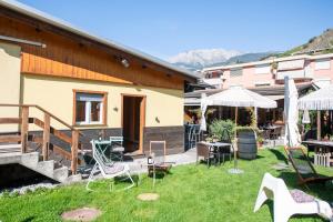 a yard with chairs and tables and a building at Motel-Restaurant 13 Etoiles in Saint-Léonard