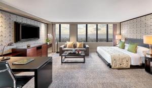 a hotel room with a bed and a couch and a tv at Mandarin Oriental, Jakarta in Jakarta