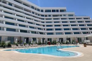 een groot gebouw met een zwembad voor een gebouw bij סי סייד אילת חדר משפחתי מפנק עם נוף לים in Eilat