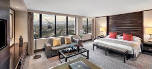 a hotel room with a bed and a couch and windows at Mandarin Oriental, Jakarta in Jakarta