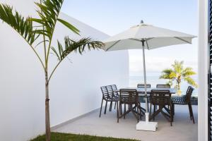 un tavolo e sedie con un ombrellone in un patio di Gorvorana 3 - Piscina privada, BBQ a Realejo Bajo